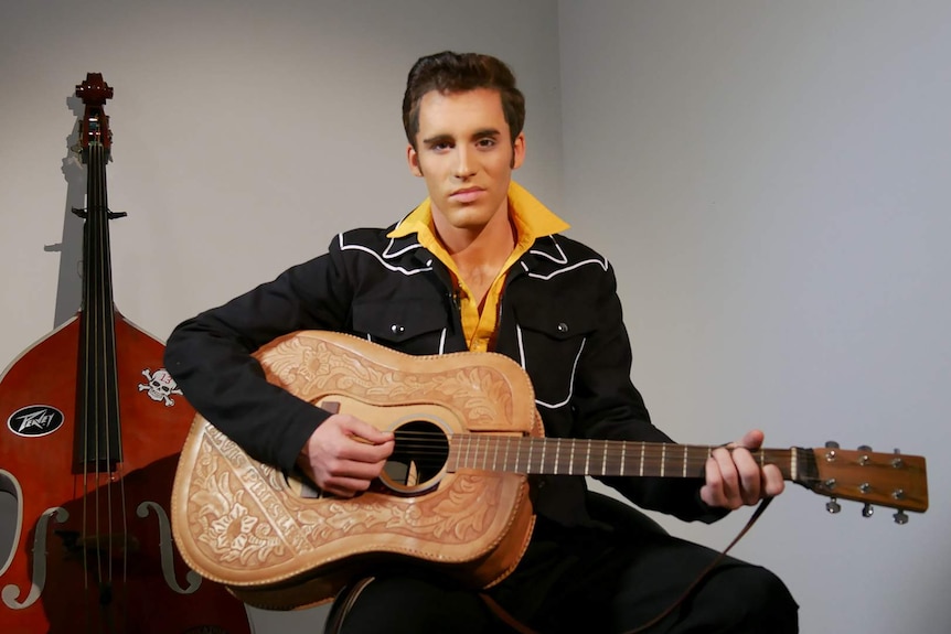 Elvis tribute artist Brody Finlay holds a guitar