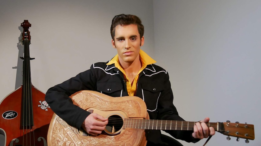 Elvis tribute artist Brody Finlay holds a guitar