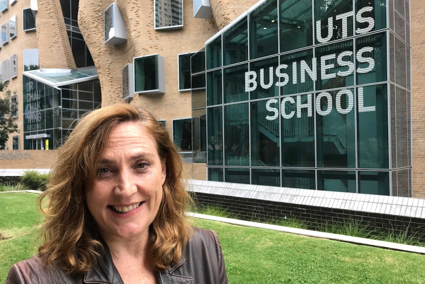 A woman in a leather jacket standing in front of the UTS building.