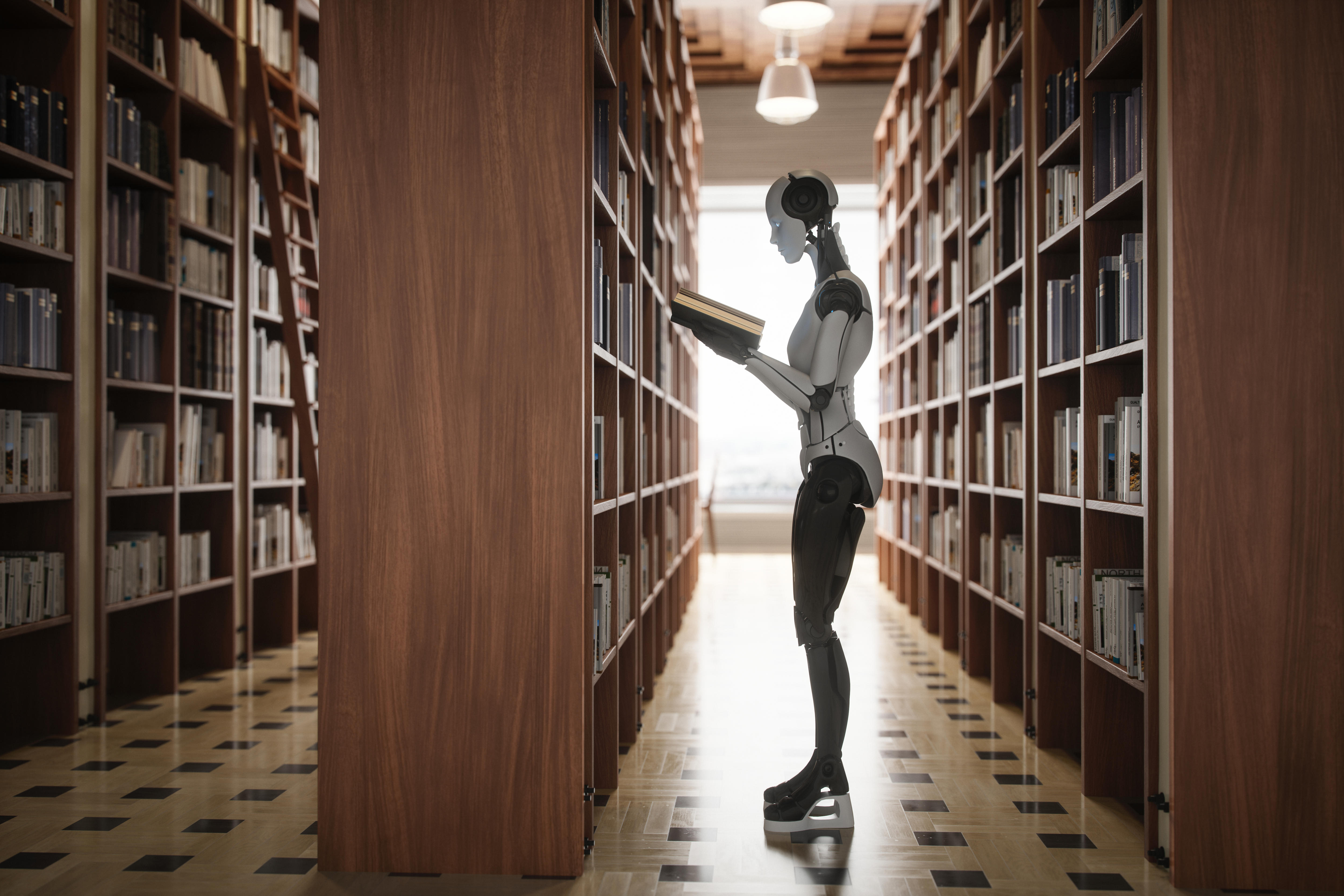 A humanoid robot stands between two bookshelves, holding a book.