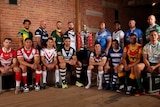 Men's rugby league captains pose with the World Cup trophy in front of exposed brick walls.