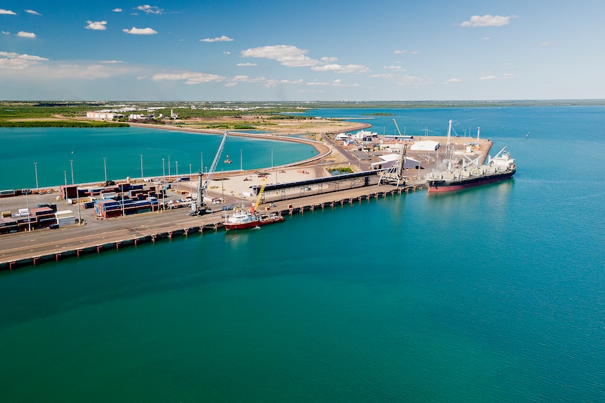 An aerial view of a wharf part of the Darwin Port, with the city of Darwin in the distance.