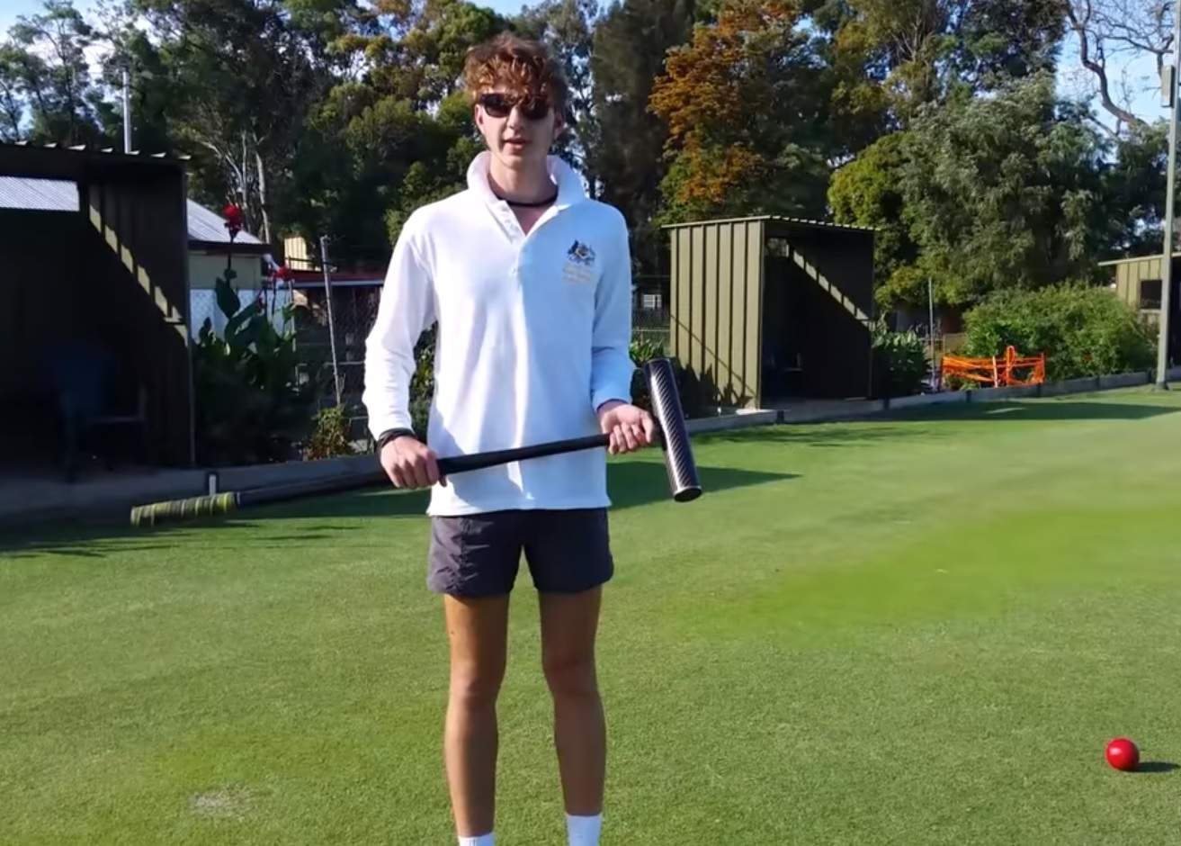 Young croquet player Edward Wilson with mallet in hand.
