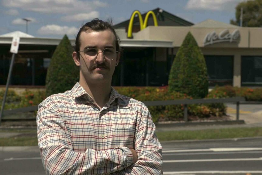 Former McDonald's employee, Max Beech, standing in front of a McDonalds