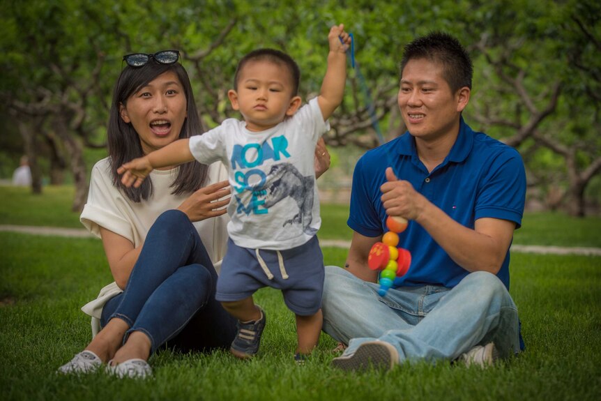 Danda and Xiaoping play with their son Ruibao at a Beijing park.