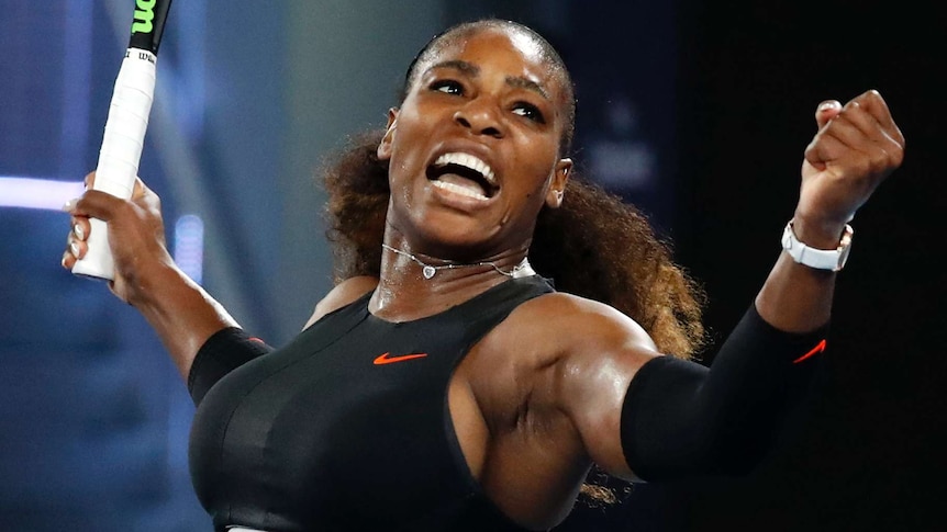 Serena Williams yells while holding up a tennis racquet