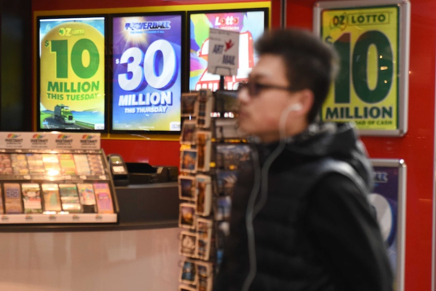 Man walking past a newsagency.