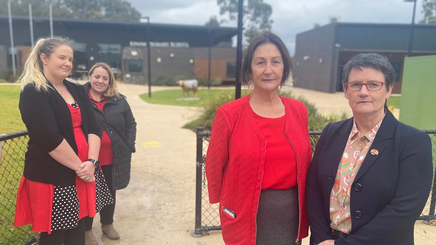 Two women of middle age looking seriously at the camera.