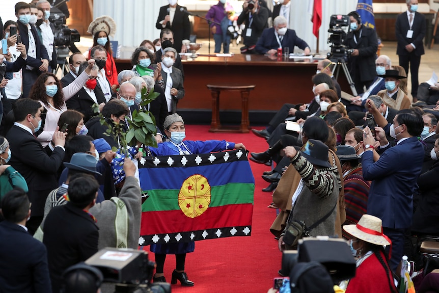 Elisa Loncon holds a Mapuch flag.