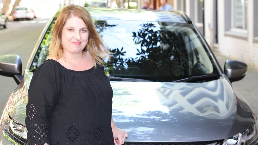 Uber driver, Rosalina Kariotakis, standing in front of her car