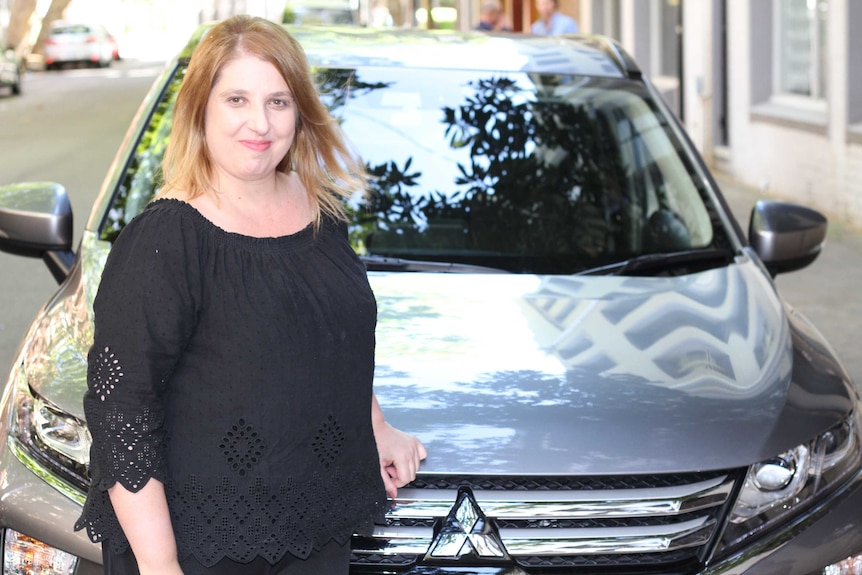 Uber driver, Rosalina Kariotakis, standing in front of her car