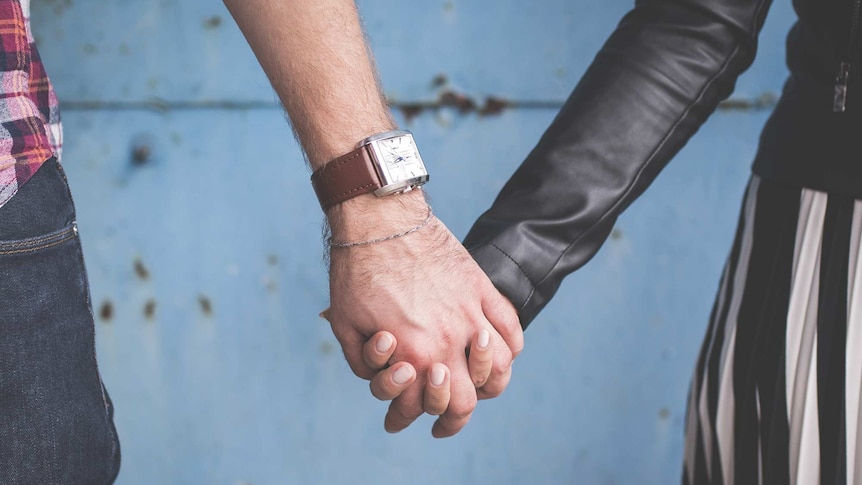 Close-up of couple holding hands for a story about supporting your partner through abortion.