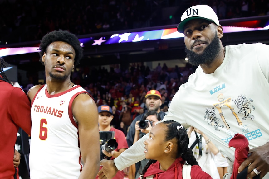 LeBron James and Bronny James on court after a USC Trojans college basketball game.