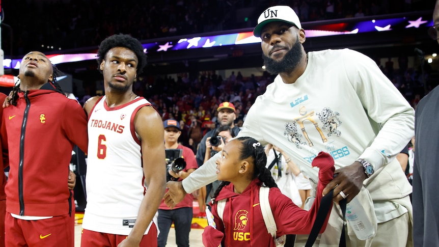 LeBron James and Bronny James on court after a USC Trojans college basketball game.