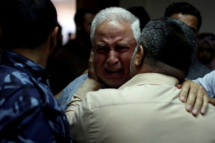 An older man is seen weeping.