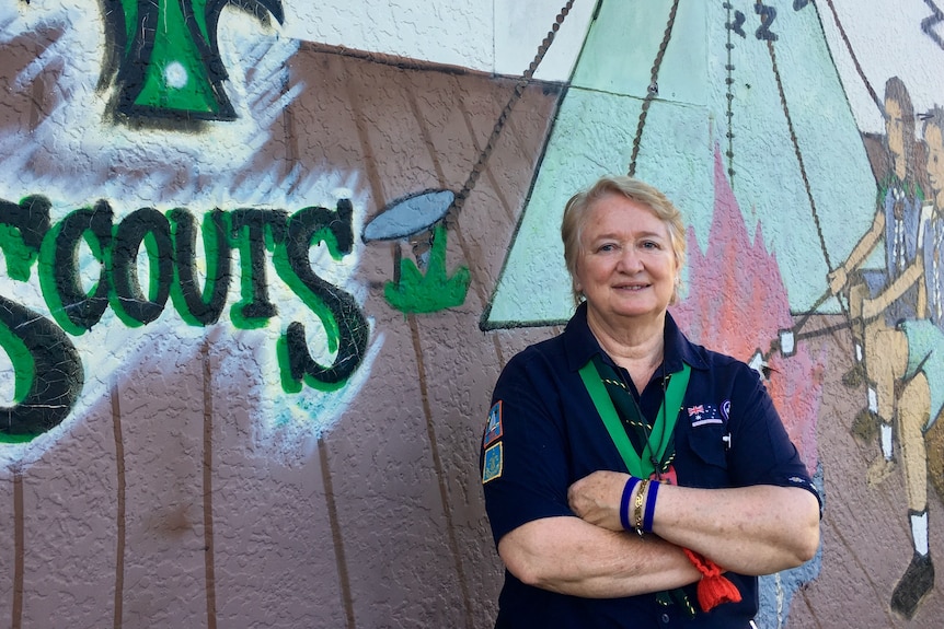 Tricia Fortier stands in front of a Scouts mural