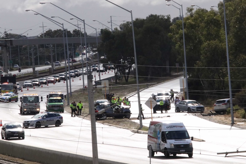 Police cars blocking traffic around a crash scene on a freeway on-ramp.