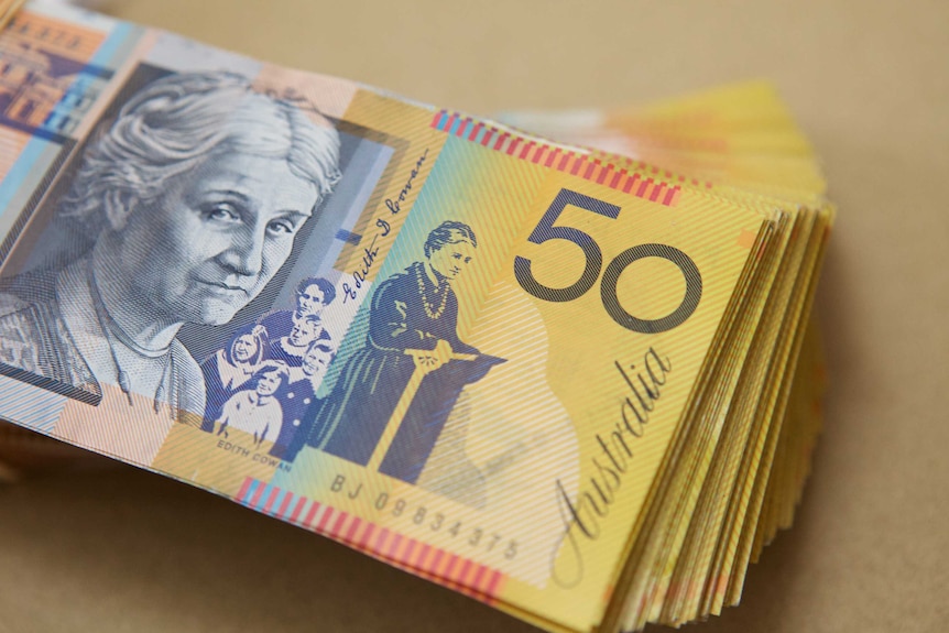 Stack of several thousand dollars of Australian $50 notes showing Edith Cowan