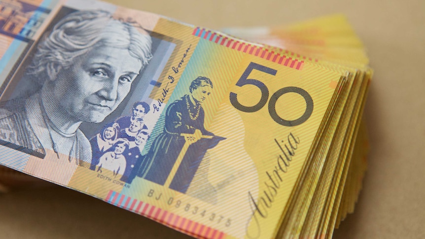 Stack of several thousand dollars of Australian $50 notes showing Edith Cowan