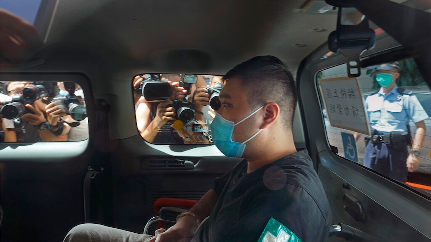 A 23-year-old man, Tong Ying-kit, pictured in a car, arriving at a court in a police van in Hong Kong Monday.