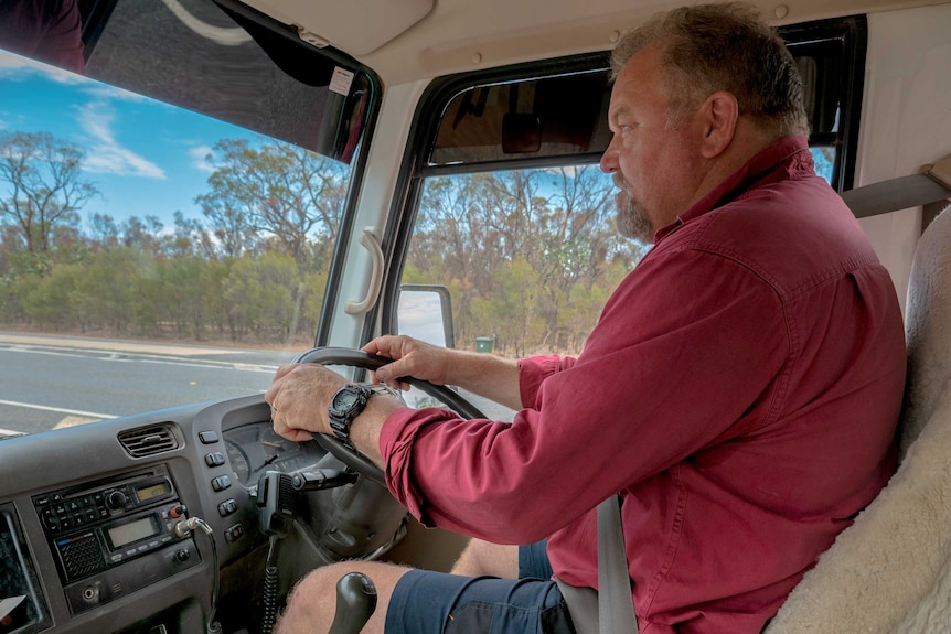 Man in bus driver seat holds steering wheel