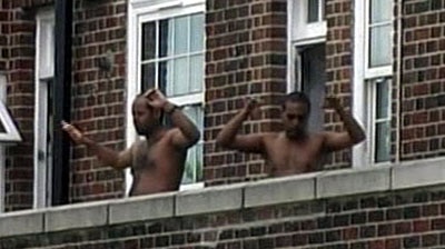 Two of the suspected London bombers raise their hands during a police raid in London (file photo).