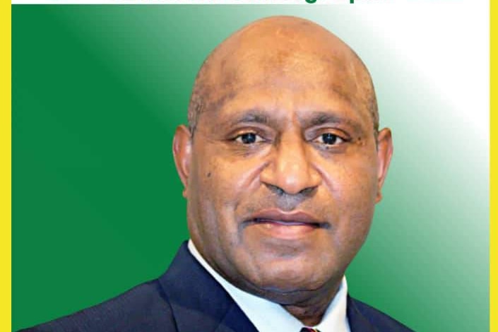 An election poster showing a bald PNG man in a suit.
