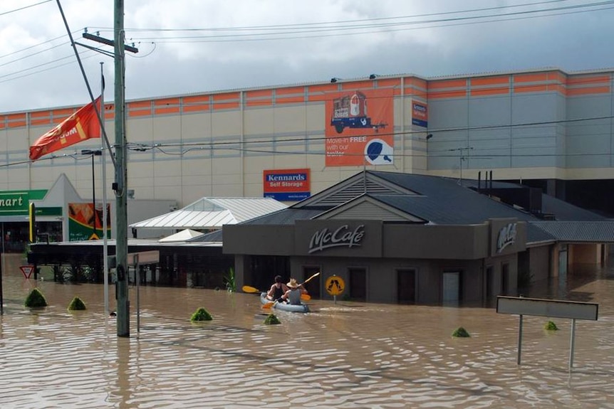 Two men paddle up to store on flooded Milton Road in Brisbane CBD on January 13, 2011.