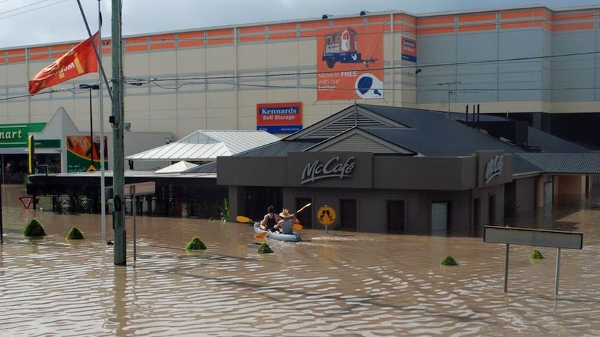 Two men paddle up to the McDonald's store in a kayak on flooded Milton Road, Brisbane on January 13, 2011.