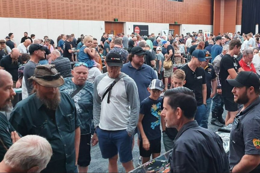 A crowd of people at a knife show.