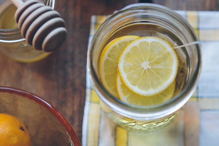 A glass of tea with lemon and honey