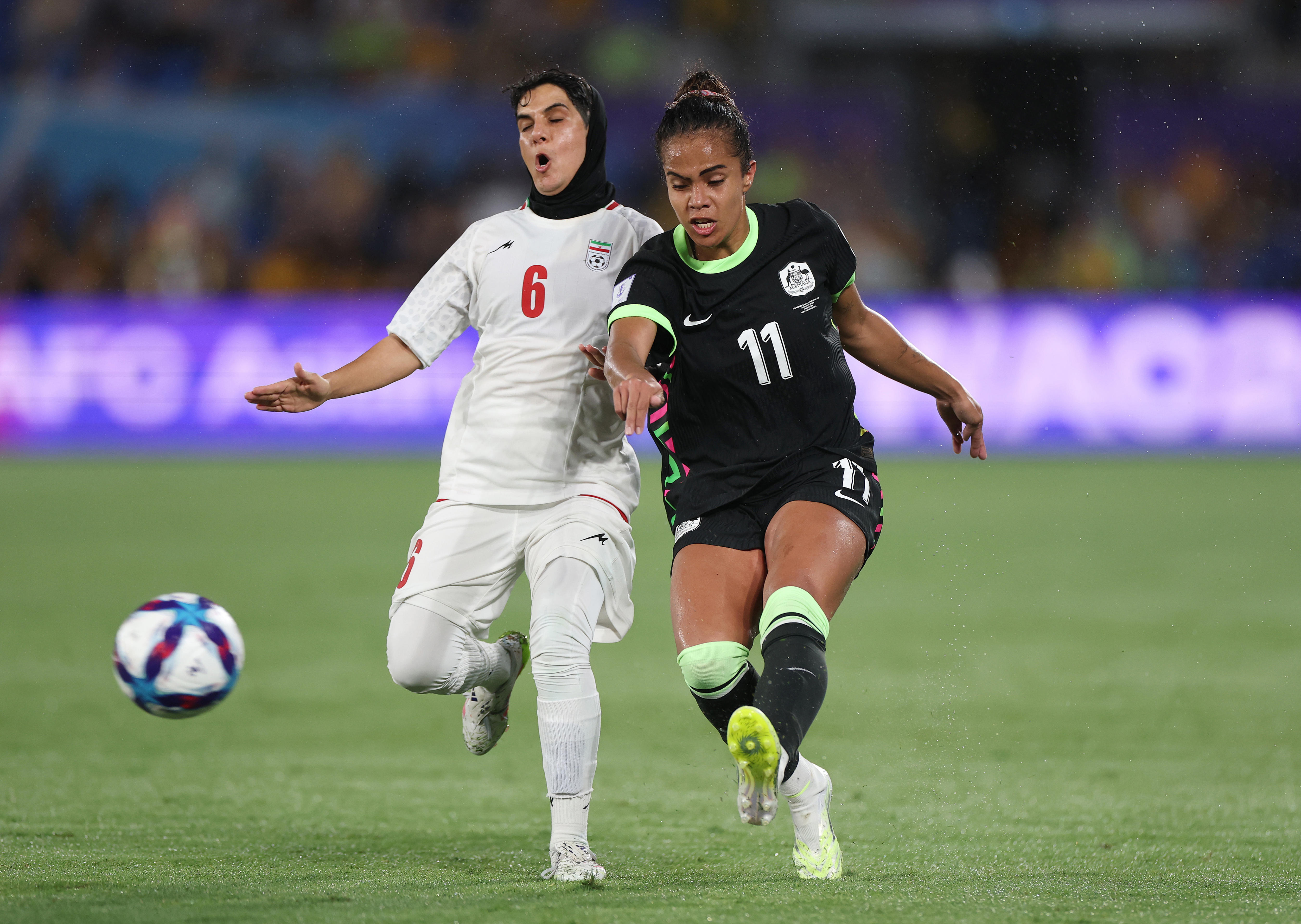 A iraniana Zahra Sarbali disputa a bola com a australiana Mary Fowler.