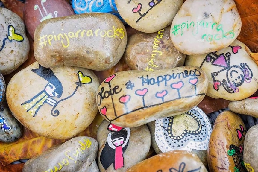 A collection of rocks painted with bright colours and positive messages.