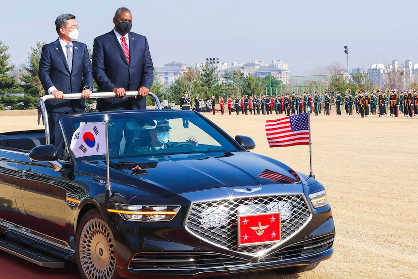 US Defence Secretary Lloyd Austin and South Korean Defence Minister Suh Wook standing up in a convertible car