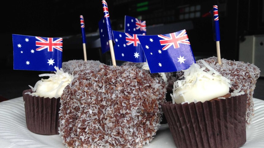 A plate of cupcakes and lamingtons with Australian flags.