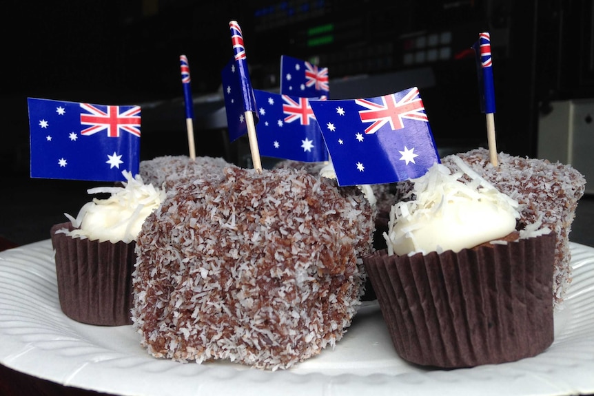 A plate of cupcakes and lamingtons with Australian flags.