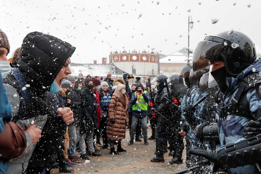 Protesters face police.