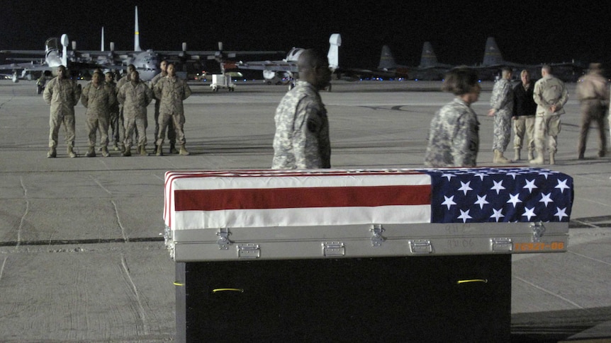 US soldiers form a guard of honour near a coffin draped in the American flag