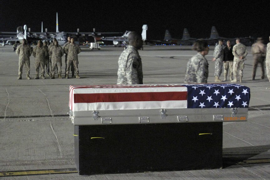 US soldiers form a guard of honour near a coffin draped in the American flag