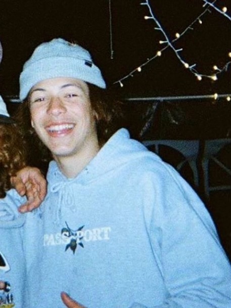 A boy smiling and wearing a beanie.