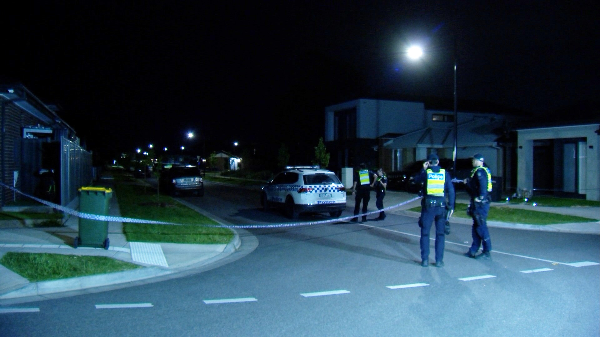 Uniformed police in a suburban street at night.