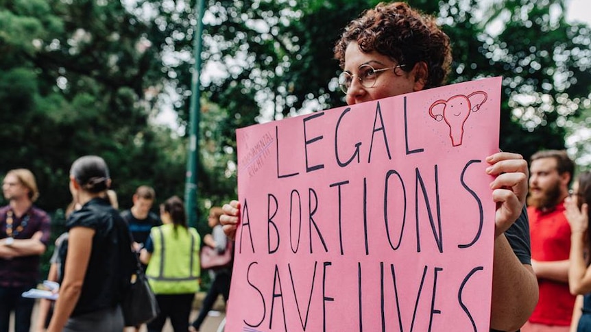 Seorang perempuan dengan poster sedang berdemo agar aborsi dilegalkan di Brisbane, November 2017.