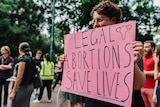 Seorang perempuan dengan poster sedang berdemo agar aborsi dilegalkan di Brisbane, November 2017.