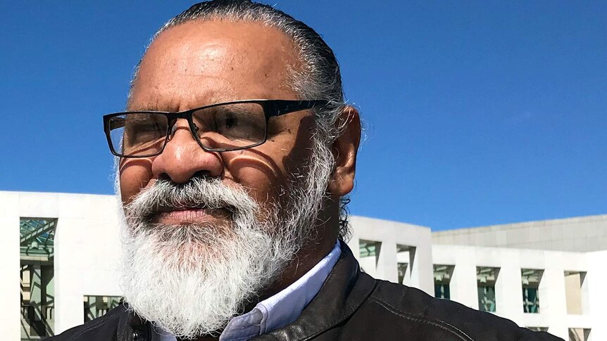 Headshot of Adrian Burragubba standing outside Federal Parliament in Canberra.