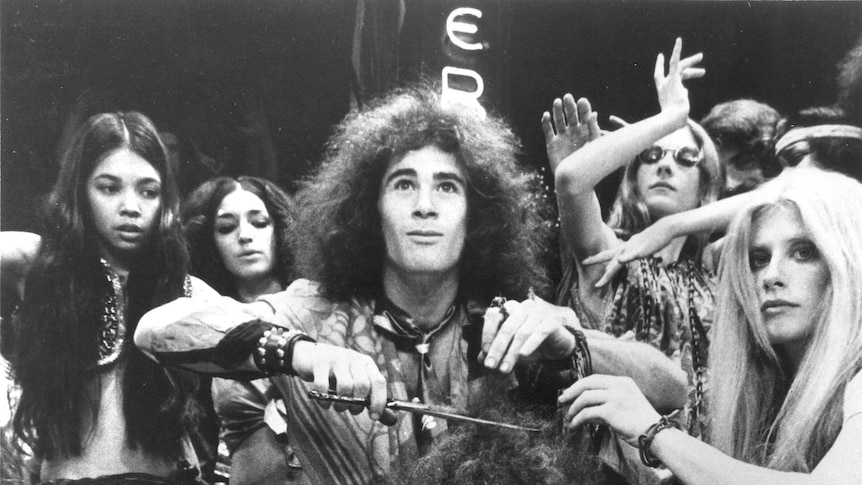A black and white photo of the 1968 Broadway cast of Hair cutting off a character's hair