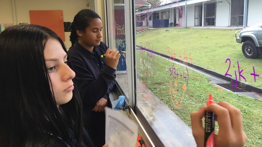 Students at Mabel Park High School solve equations on the classroom window