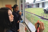 Students at Mabel Park High School solve equations on the classroom window