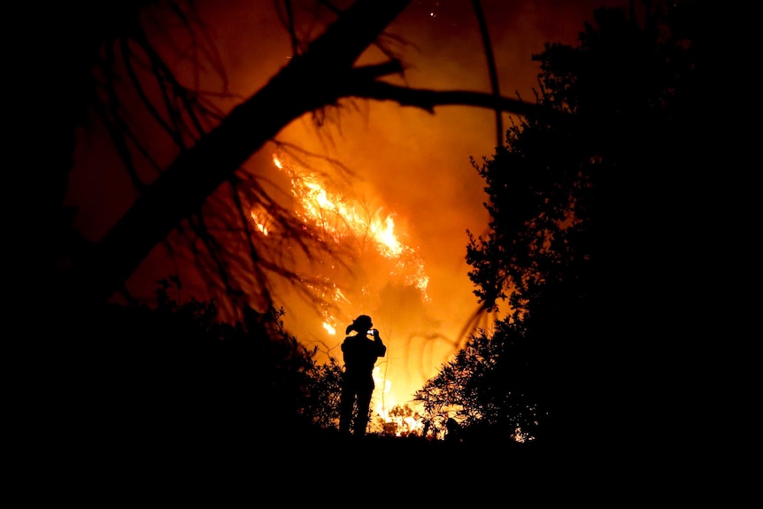 A firefighter takes a picture on his mobile phone during the California wildfires.