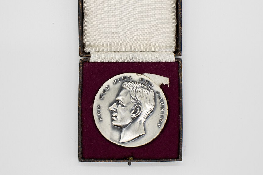 A silver medal in a case.
