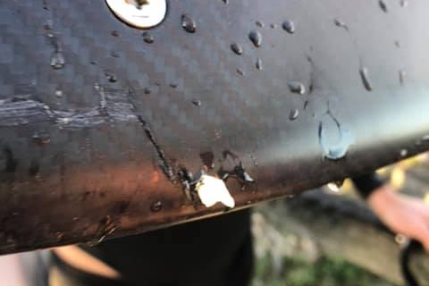 A black foil board with a shard of tooth embedded in it.